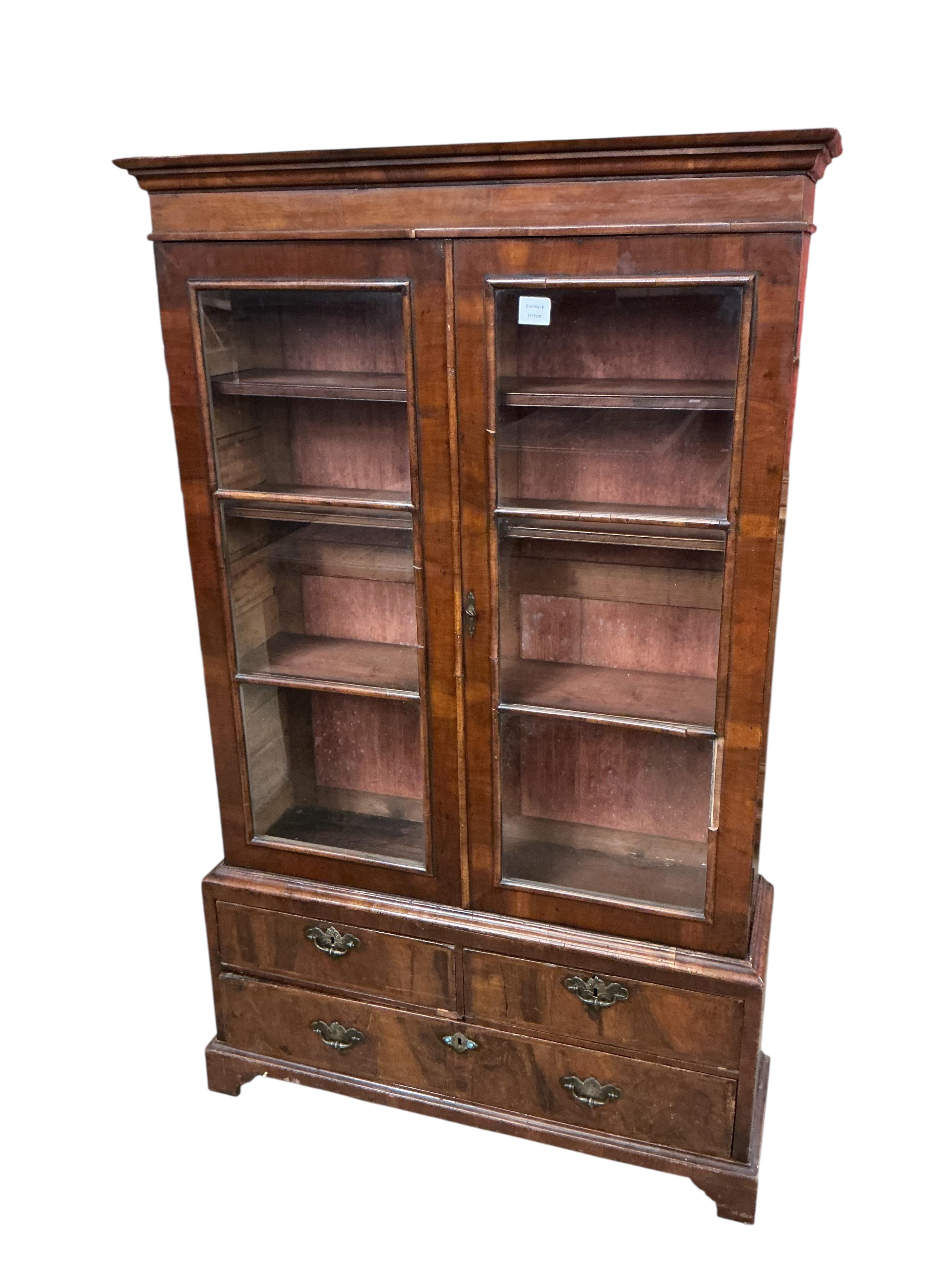 A Queen Anne Revival walnut two door bookcase, the base fitted with drawers, width 92cm, depth 27cm, height 154cm